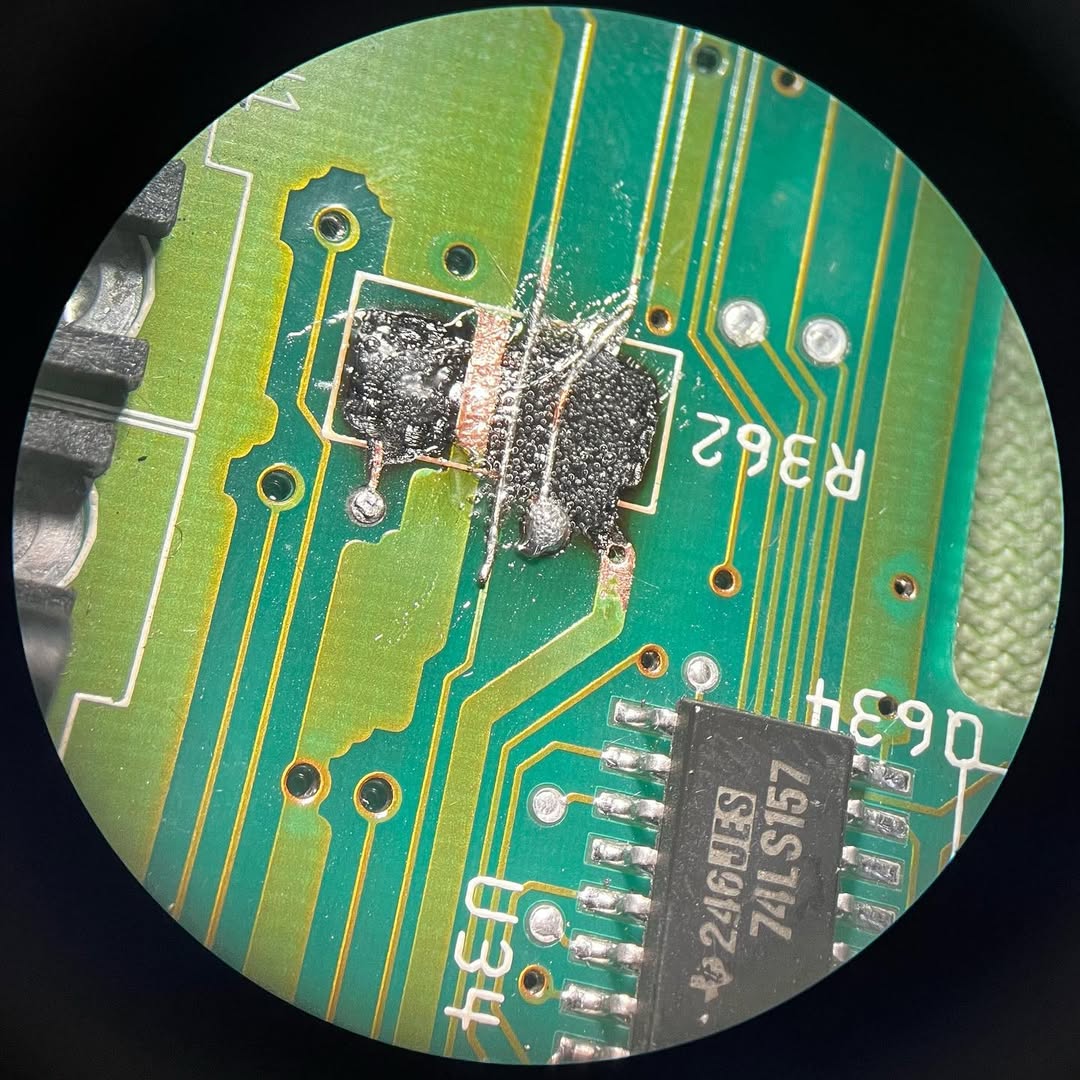 Dettaglio sotto microscopio della zona riparata con filo in rame e pasta saldante su Amiga 600